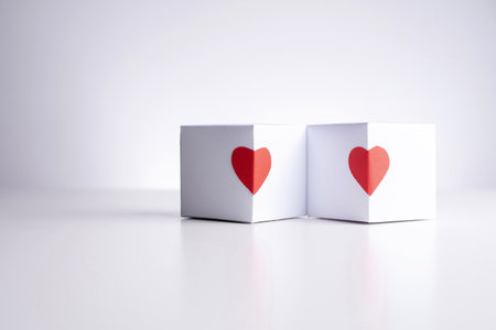 Two white boxes with red hearts  on a white background, close up, copy space.の写真素材