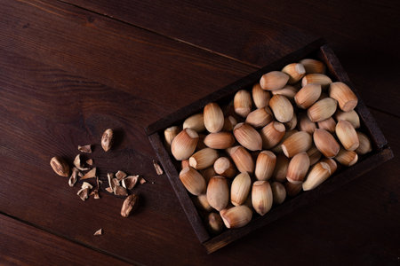 hazelnuts in a wooden box on a wooden table.