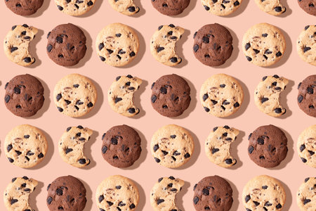 A pattern of chocolate chip cookies on a light brown background, top view
