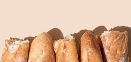Pieces of crispy baguette on a yellow background in sunlight, banner, close up.の写真素材