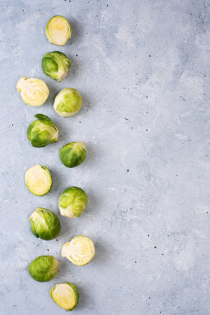 Row of fresh brussels sprouts on gray background, copy space, close up.