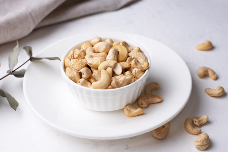 Raw nuts in a bowl on a white background, vegetarian food, raw eating, close up.