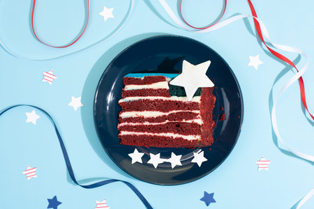 Celebrating Independence Day, a piece of cake in the form of the USA flag with white, red and blue...