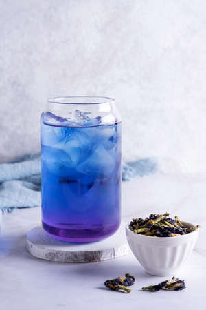Blue anchan herbal drink, iced butterfly pea flower tea and dry clitoria ternatea flower on white background.の写真素材