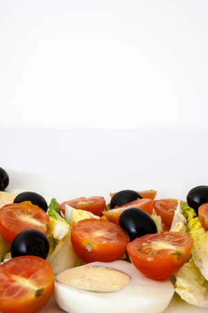 Salad with black olives, eggs, cherry tomatoes and lettuceの写真素材