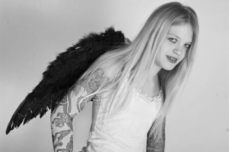 bad gothic teenage angel with tattoo on her armsの写真素材