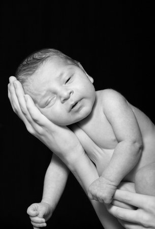 newborn baby falling asleep in mom's arms.