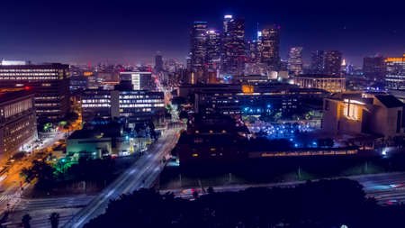 Cinematic aerial view of urban downtown Los Angeles city skyline and streets at nightのeditorial素材