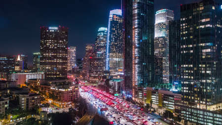 Cinematic aerial view of urban downtown Los Angeles city skyline and streets at nightのeditorial素材