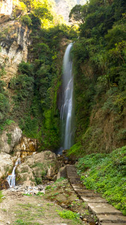 Waterfall on the way to Annaourna circuit, covered with green bushes and trees Tal Nepalの写真素材