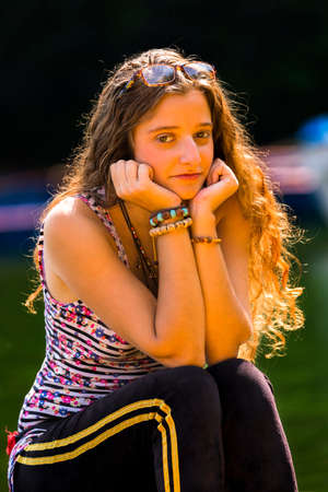 Portrait of beautiful Girl Sitting on a Boat in Lakeside,She has trendy golden color in her hair and beautiful skin.の写真素材
