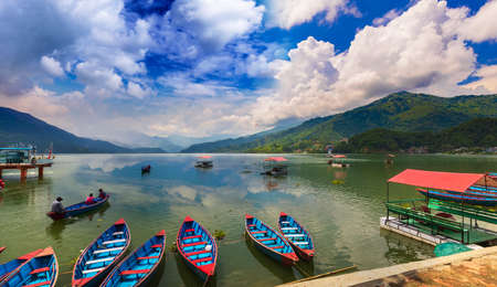 Beautiful View of Phewa Lake and colorful boats with blue sky on the background Pokhara Nepalのeditorial素材
