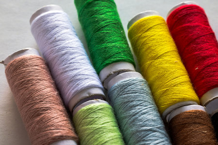 Colorful spools of Threads on a white background. typically showcase a vibrant collection of sewing...