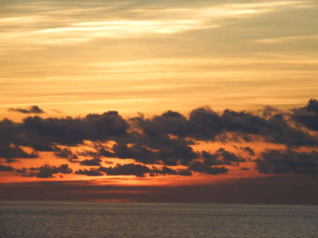 Dramatic sunset orange sky over waterの写真素材