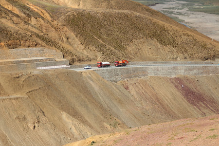 Car and trucks on the China National Highway 318 (G318) running through mountains in Tibet, China