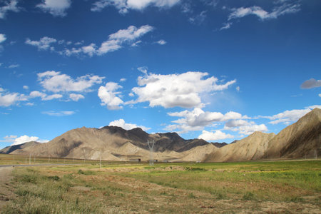 View of the mountain and Tibetan village with dramatic sky in Tibet, Chinaの写真素材