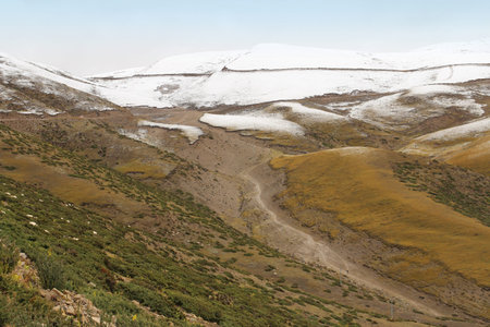 View of mountains with the dirt road in Tibet, Chinaの写真素材