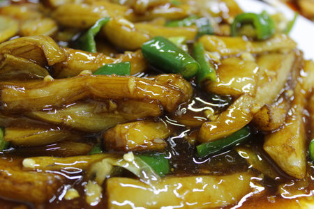 Close up of stir fried eggplants with potato and green pepper in gravy soy sauceの写真素材