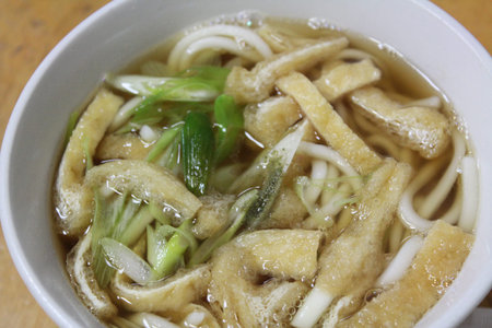 Bowl of hot Udon with green onion and sliced bean curd puffs in Osaka, Japan