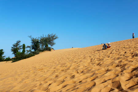 Mui Ne, Vietnam - June 27, 2017: A child sand boarding with the slide boardのeditorial素材