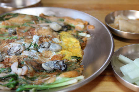 Focus on oyster on the Korean pancake with the leek and egg at Korean restaurant, Busan, South Koreaの写真素材