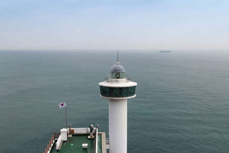 Yeongdo Lighthouse against the blue sea and sky at Taejongdae park, Busan, South Koreaの写真素材