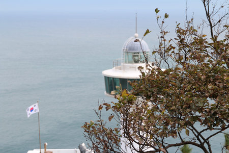 Yeongdo Lighthouse with the Korea flag at Taejongdae park, Busan, South Koreaの写真素材