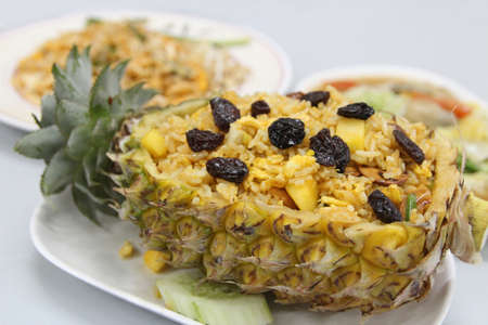 Thai pineapple fried rice with the pineapple, cashew nut, egg and raisin on topの写真素材