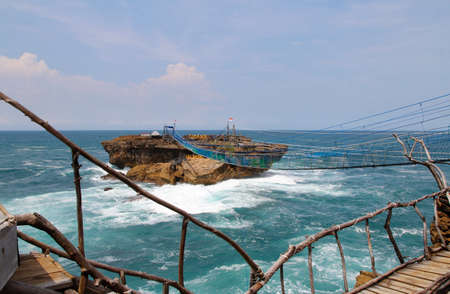 Suspension bridge connecting to the Timang Beach in sunny day, Yogyakarta, Indonesiaの写真素材
