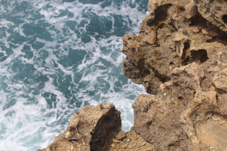Close-up of natural rock formation with the wave at Timang Beach in sunny day, Yogyakarta, Indonesia