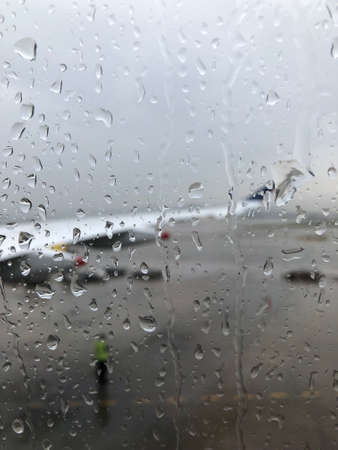 Raindrops on airplane window during take off on a runway at Barcelona airportの写真素材
