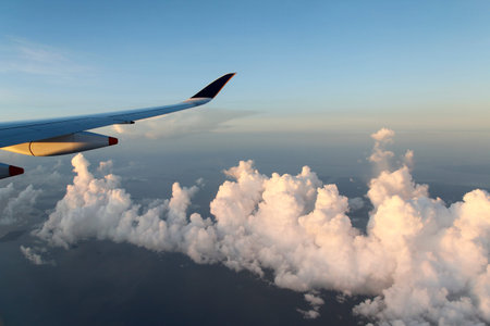 Dramatic cloudscape with the airplane's wing during sunrise from the airplane's window