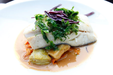 Haddock loin with shellfish juice, roast artichokes and carrots as the main course for dinner in...