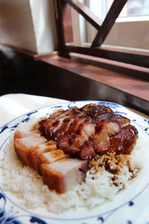 Roast duck, roast pork (char siu) and crispy pork belly (siu yuk) with rice in a Chinese restaurantの写真素材