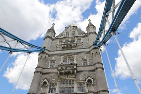 Top part of Tower Bridge with the blue sky and clouds on a bright sunny day in spring, London, UK