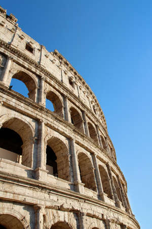 The exterior facade of the Colosseum or Coliseum with the arches against blue clear sky in Rome, Italyの写真素材
