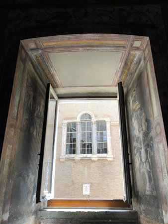 View through a window from the Vatican Museum with the painting on the wall