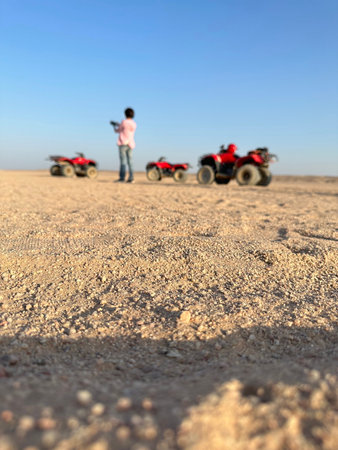 View of Quad bike on the desert and a woman taking photo in a sunny afternoon at Hurghada, Egypt