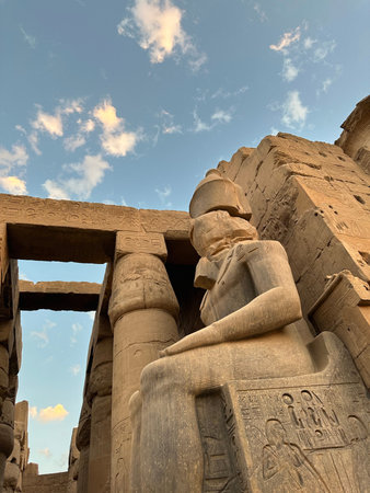 Colossus of seated Ramesses II at Temple of Luxor during sunset, Egypt