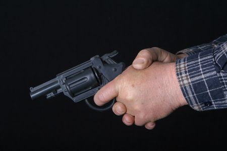 Black 9mm gun in man's hand aimingの写真素材