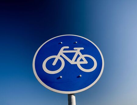 Bike lane traffic sign over blue skyの写真素材