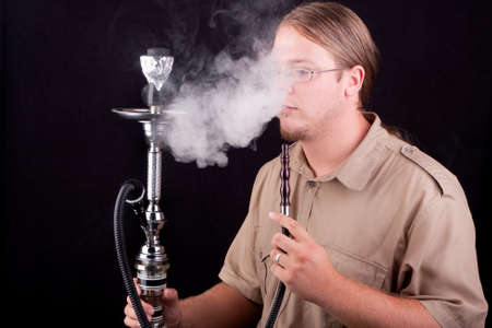a young man smoking hookahの写真素材