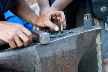 blacksmith working on anvil with hammer