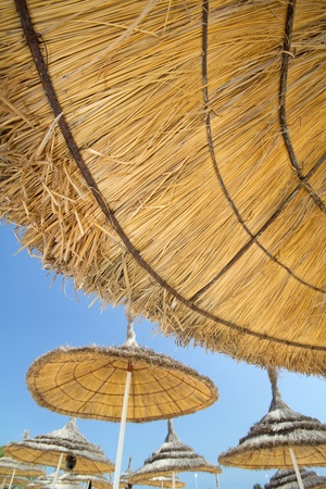 straw beach umbrella with blue skyの写真素材