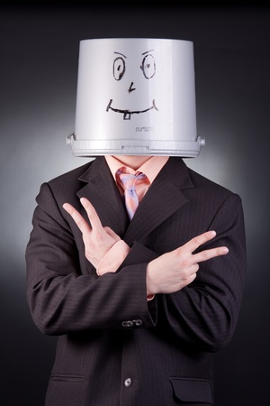 funny businessman with a bucket on his headの写真素材