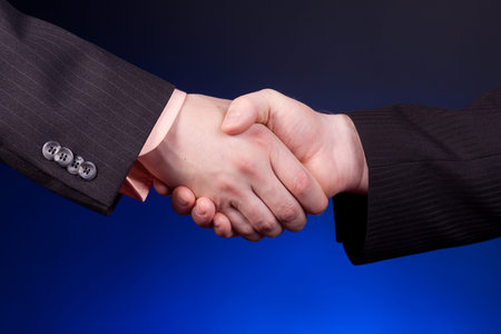 two businessman shaking hands over blue background