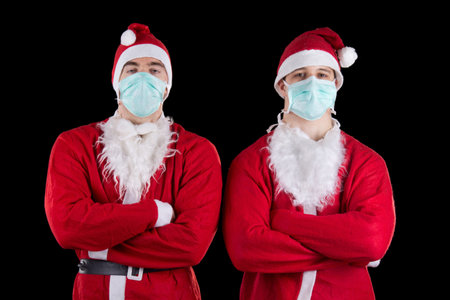 Two santa claus wearing mask