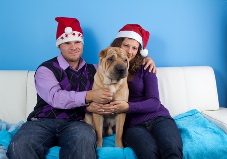 happy couple celebrating christmas wit sharpei dogの写真素材