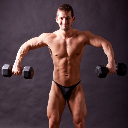 young bodybuilder traininig over balck backgroundの写真素材