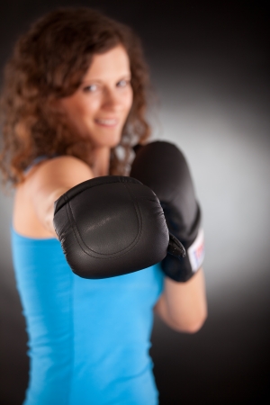 Young beautiful sporty woman with box gloves -focus on gloveの写真素材